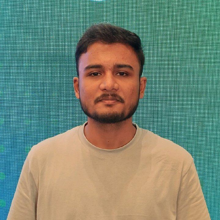 Portrait of Adil Sameer, technical co-founder, in front of a teal LED wall